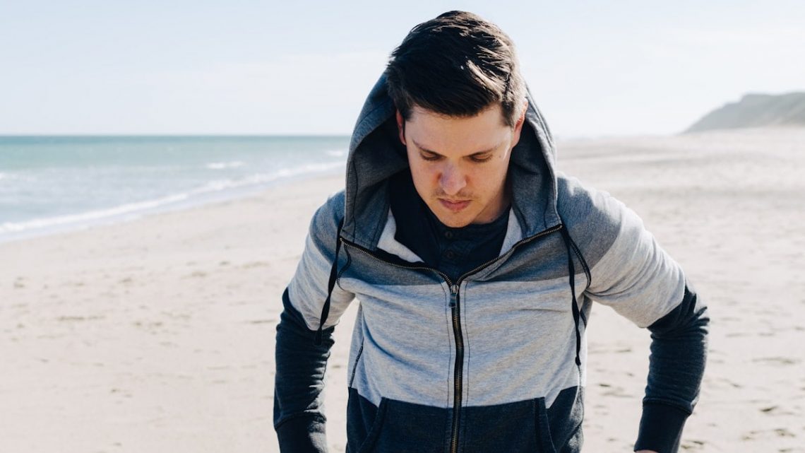 Man on a Beach in a Sweatshirt