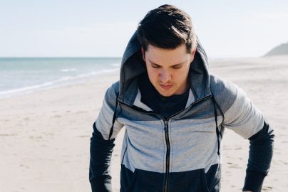 Man on a Beach in a Sweatshirt